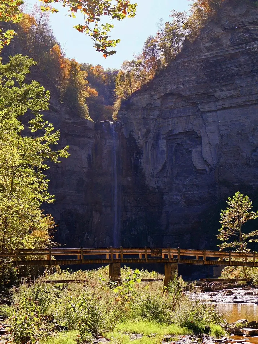 Photo taken by Colette Rathke showcasing a small waterfall and a bridge